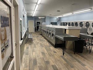 Interior of the renovated Suds On Belcher laundromat with rows of new washers and dryers