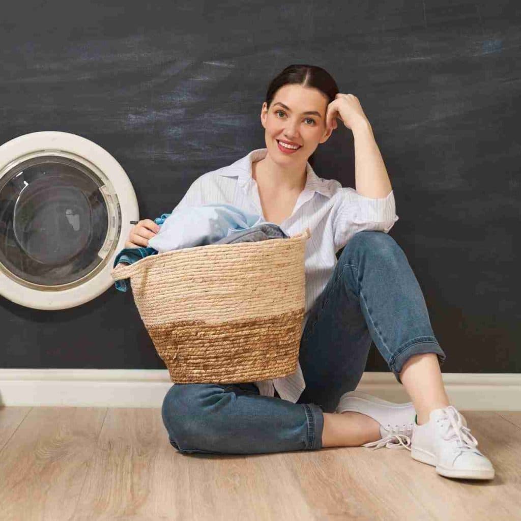 A customer holding a basket of freshly folded laundry